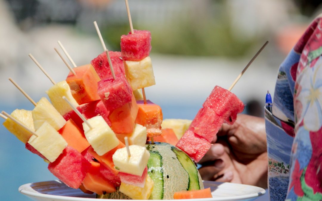 a white plate topped with watermelon and pineapple skewers